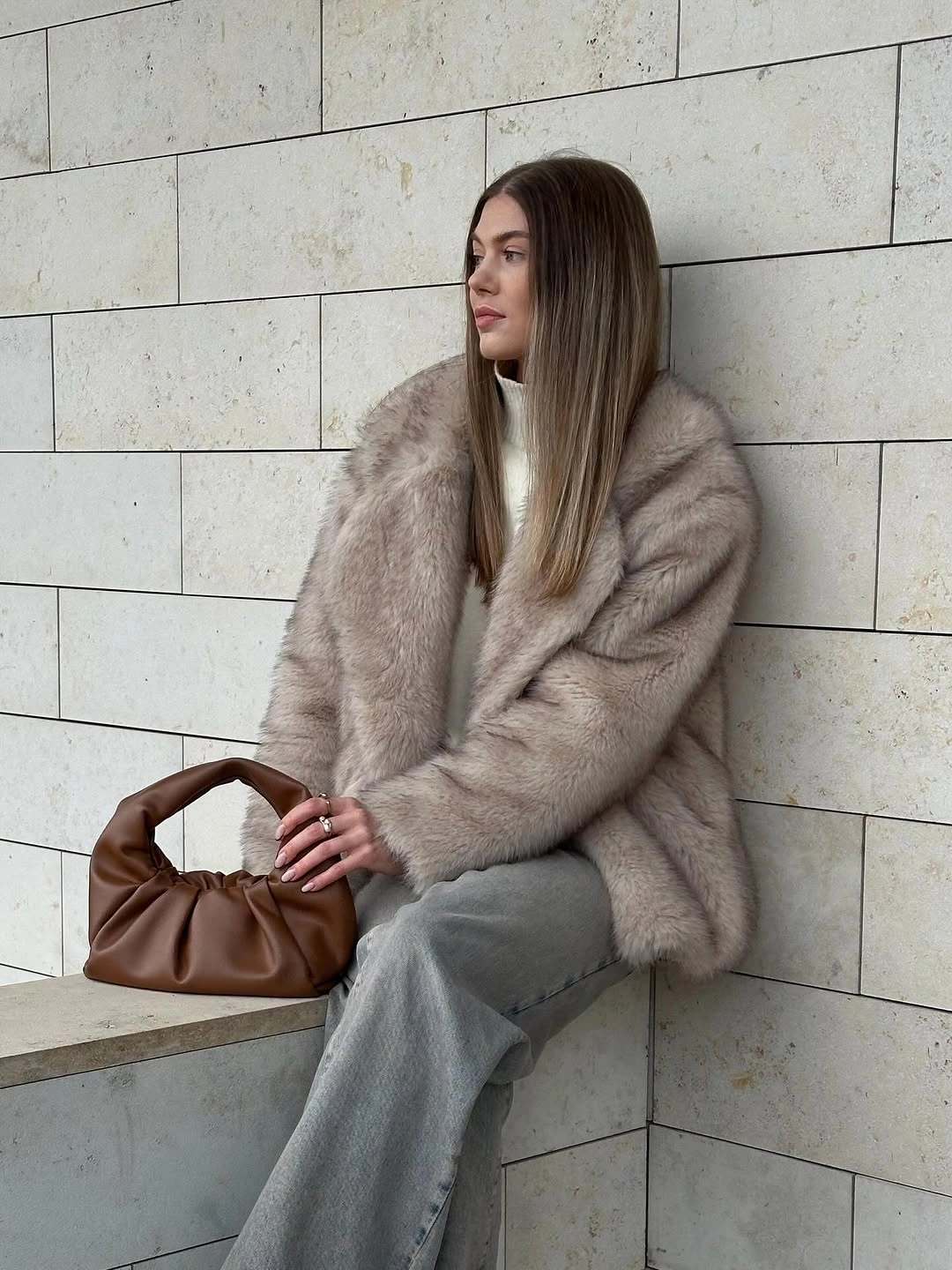 Taupe fuzzy outer layer with gray jeans and brown gathered bag