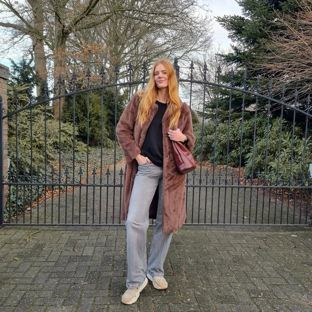 Long brown textured coat with gray wide jeans and shoulder bag
