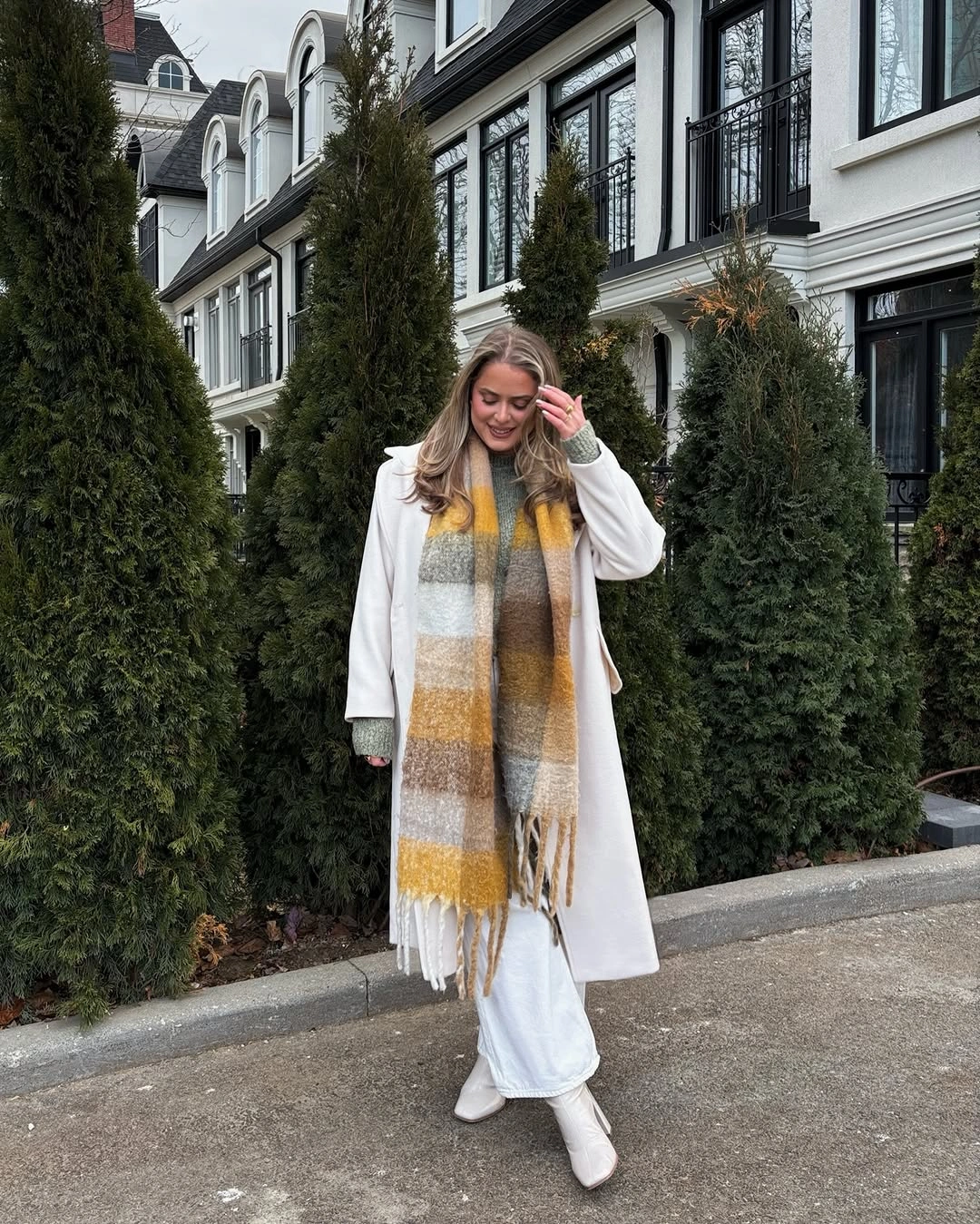 White long coat with gray and mustard checked scarf