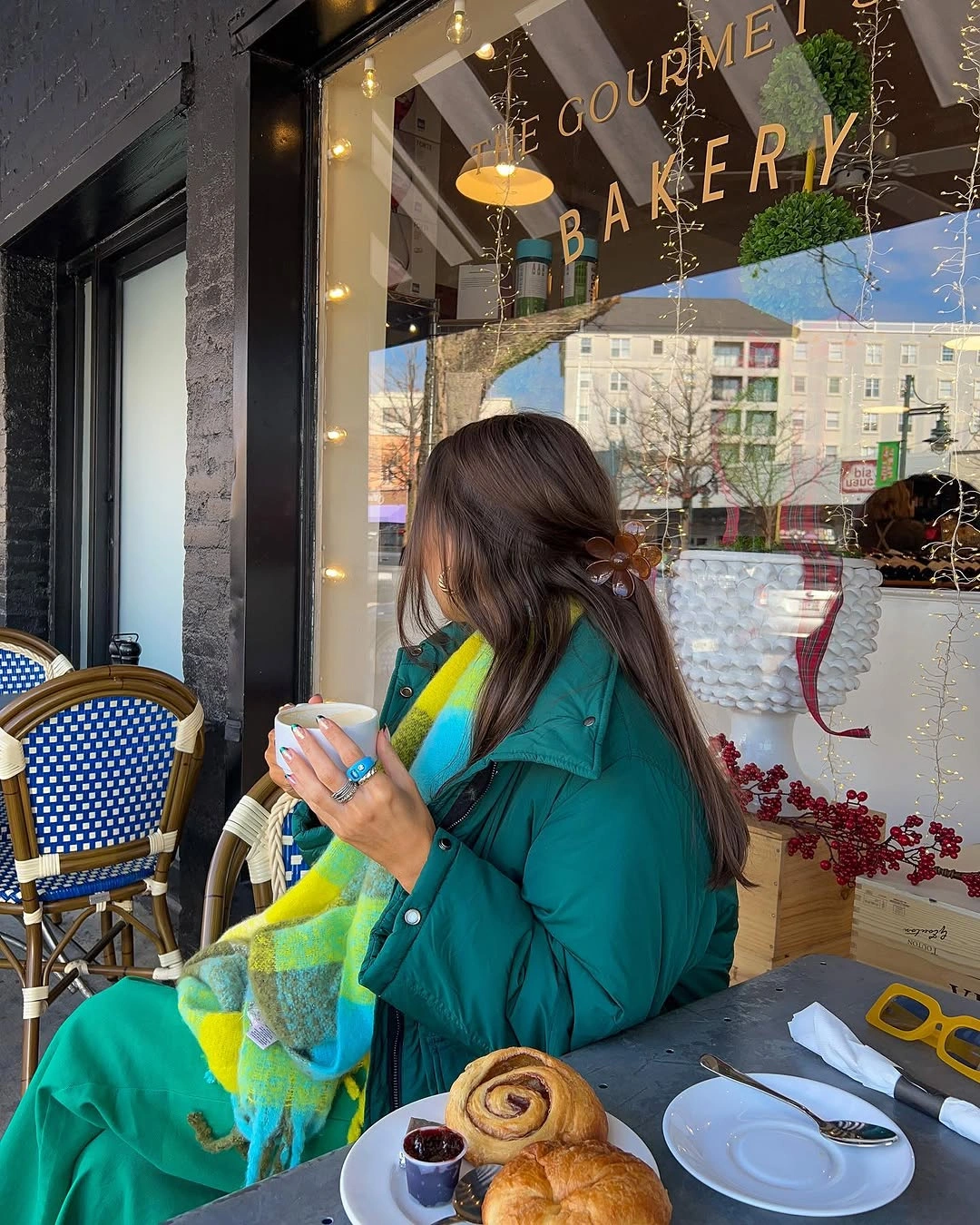 Teal puffer jacket with a bright multicolor striped scarf
