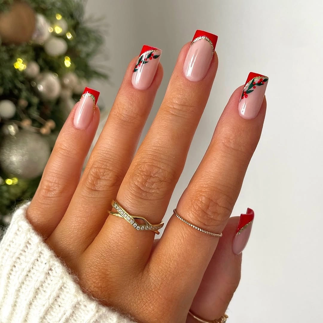 Long square nails with red tips and green leafy accents