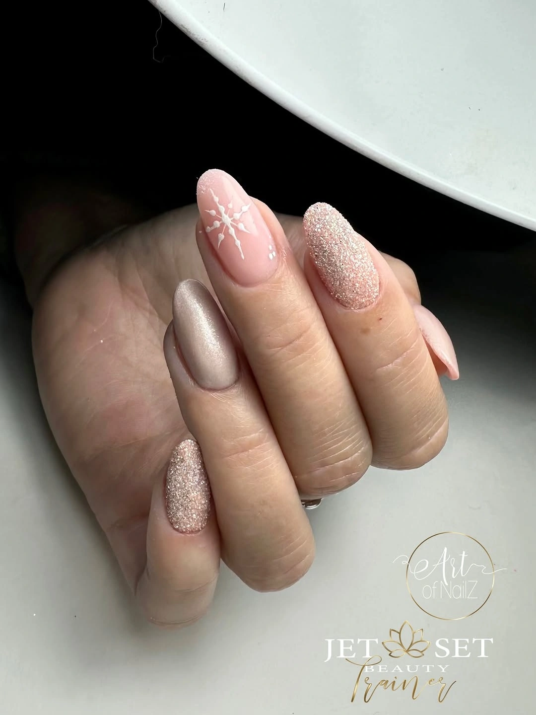 Oval neutral nails with champagne glitter and white snowflake detail