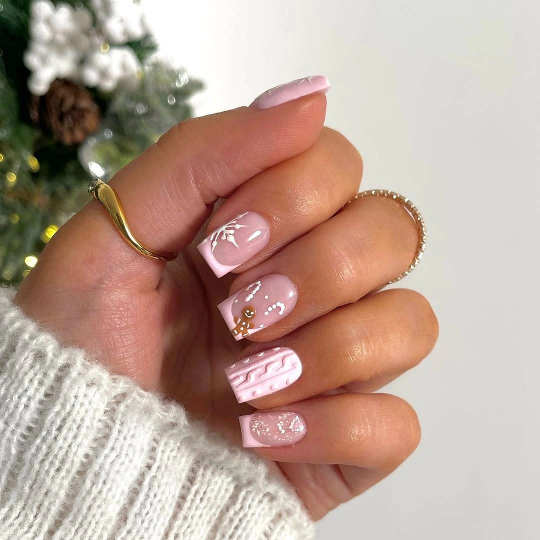 Short square pink nails with snowflakes, dots, glitter, and texture