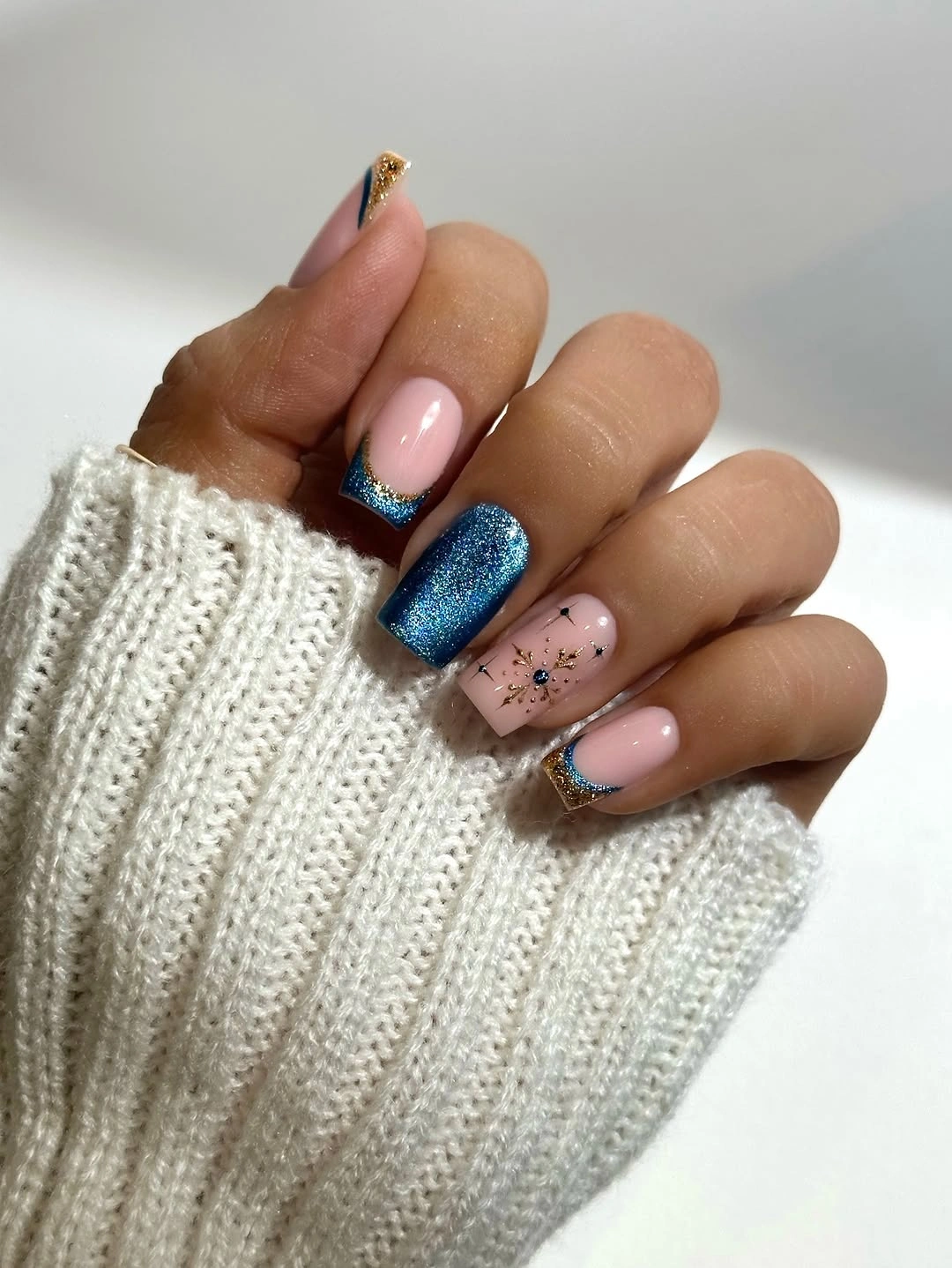 Almond-like nails with blue glitter tips and starburst accents