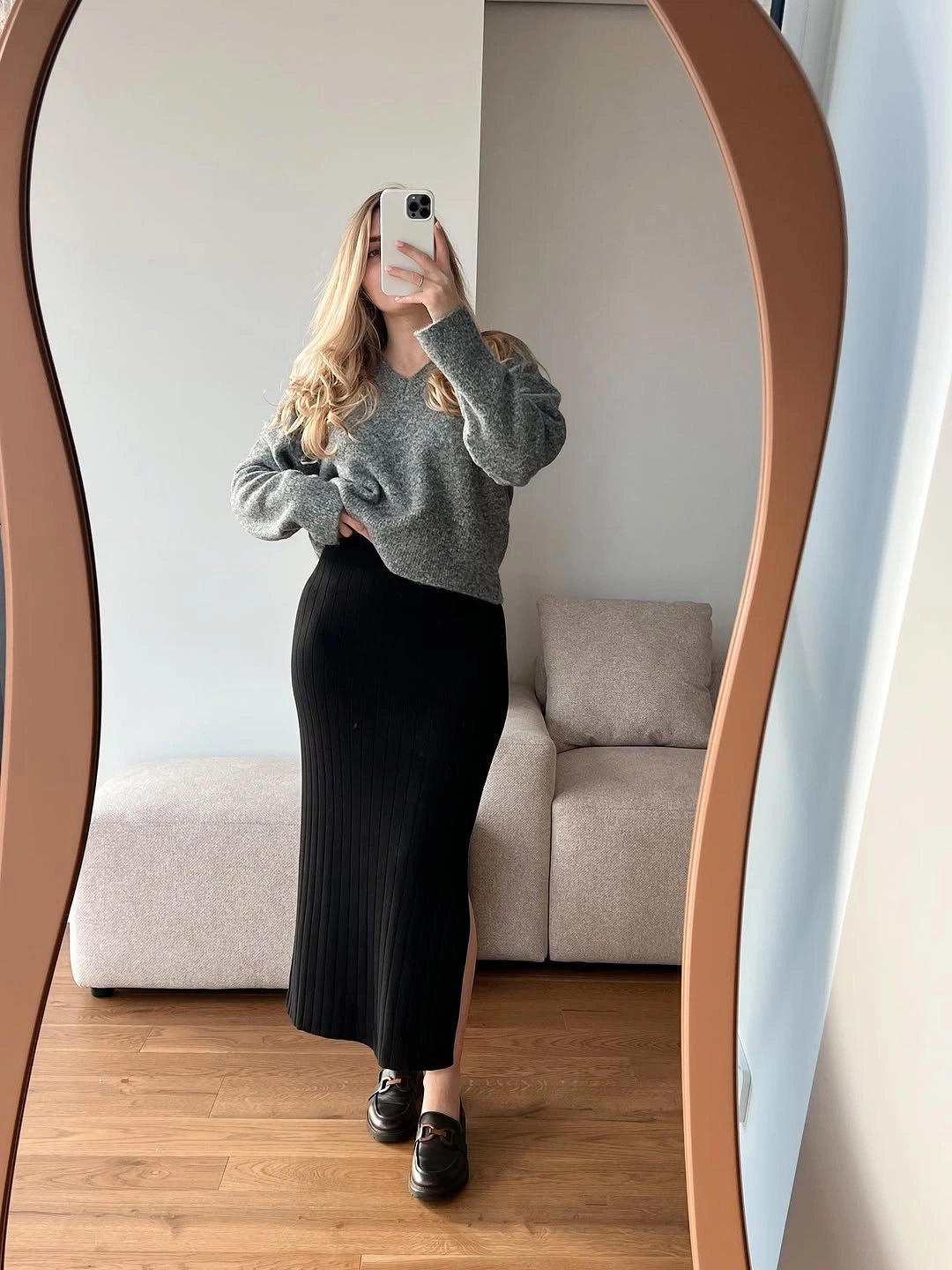 Gray sweater with black ribbed skirt and black loafers