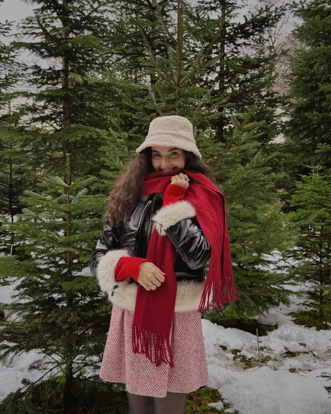 Red scarf with black jacket and pink patterned short skirt
