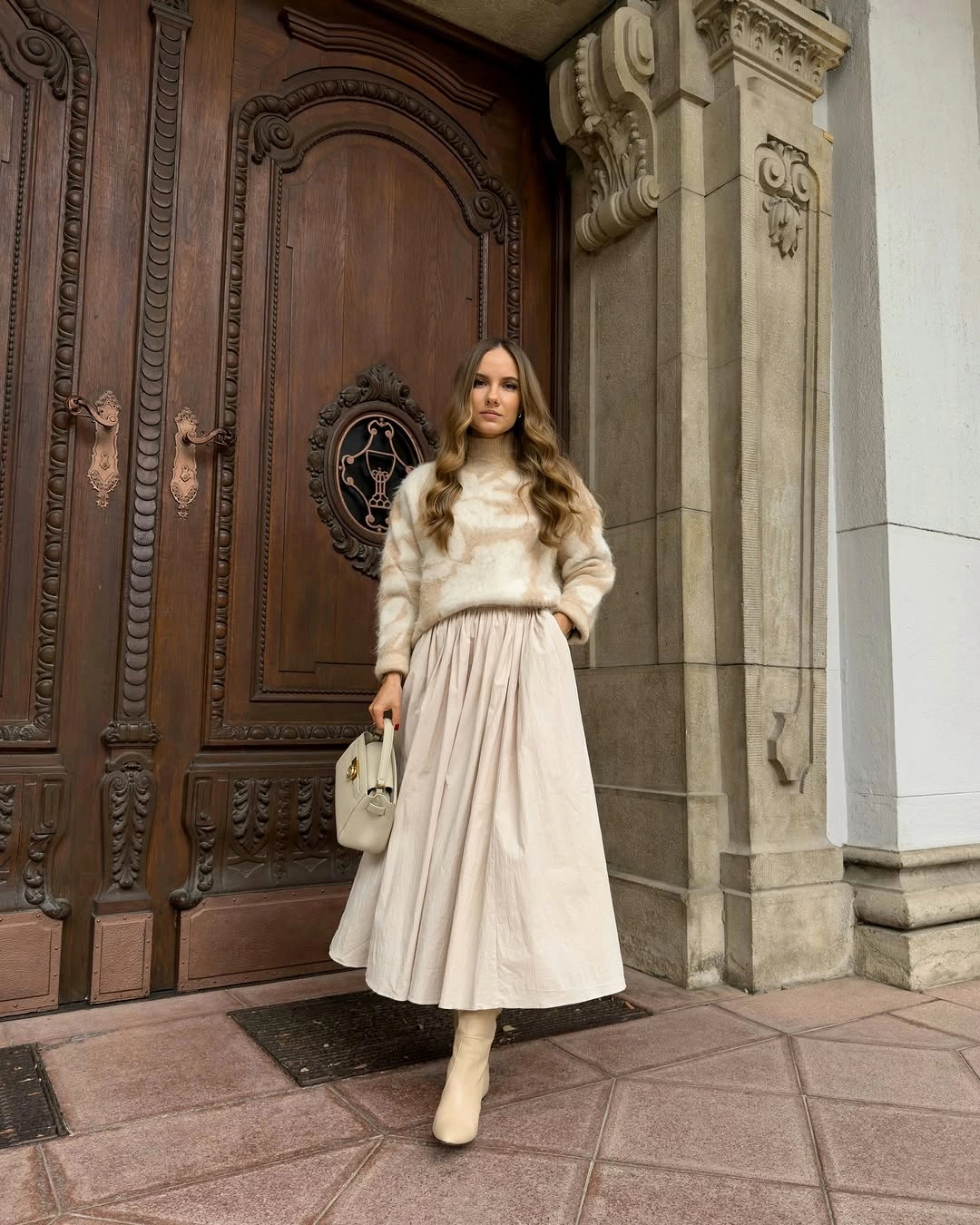 Fluffy-looking cream sweater with full pale skirt and boots
