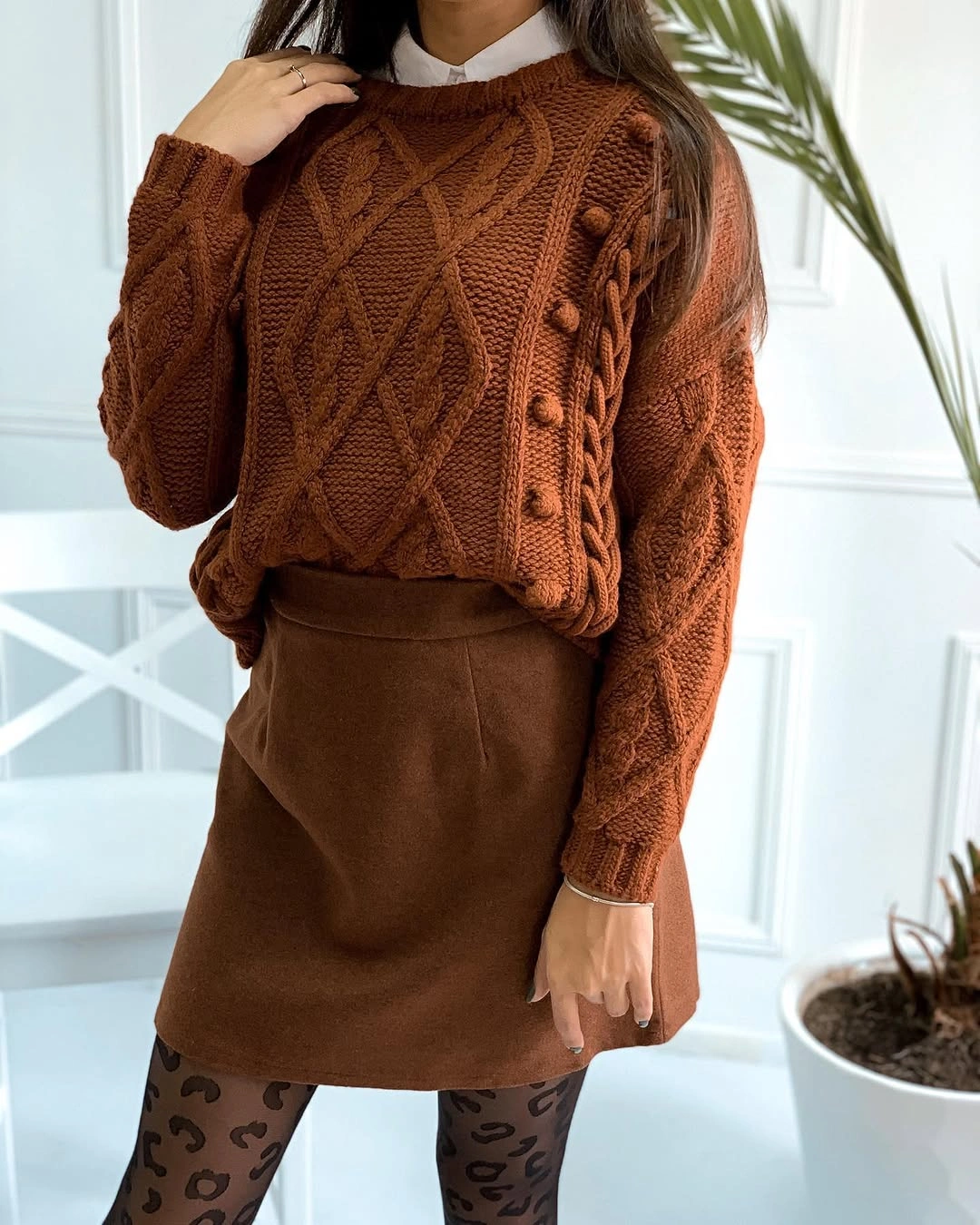 Rust textured sweater with brown mini skirt and patterned tights