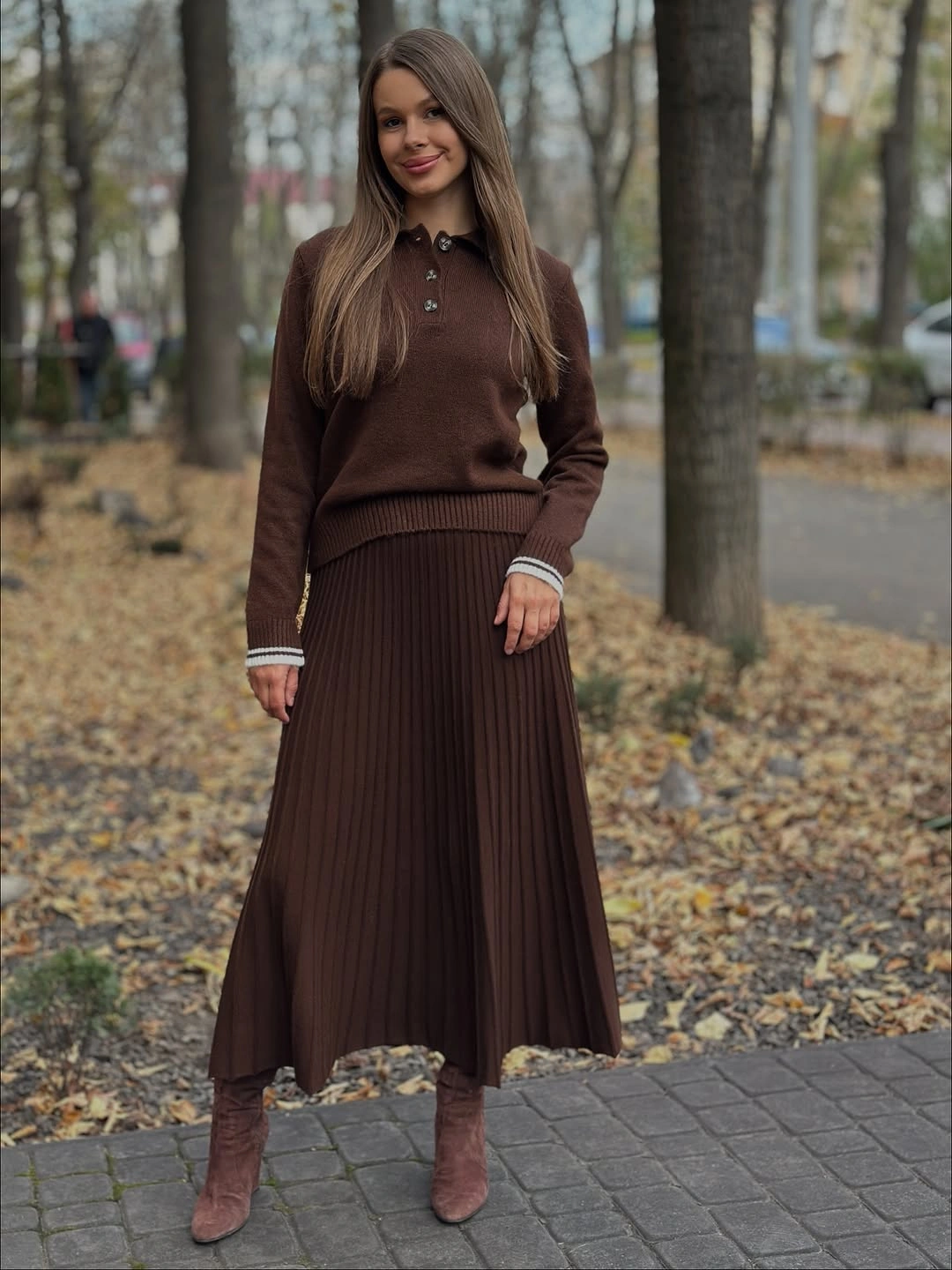 Brown collared knit top with long pleated skirt and boots