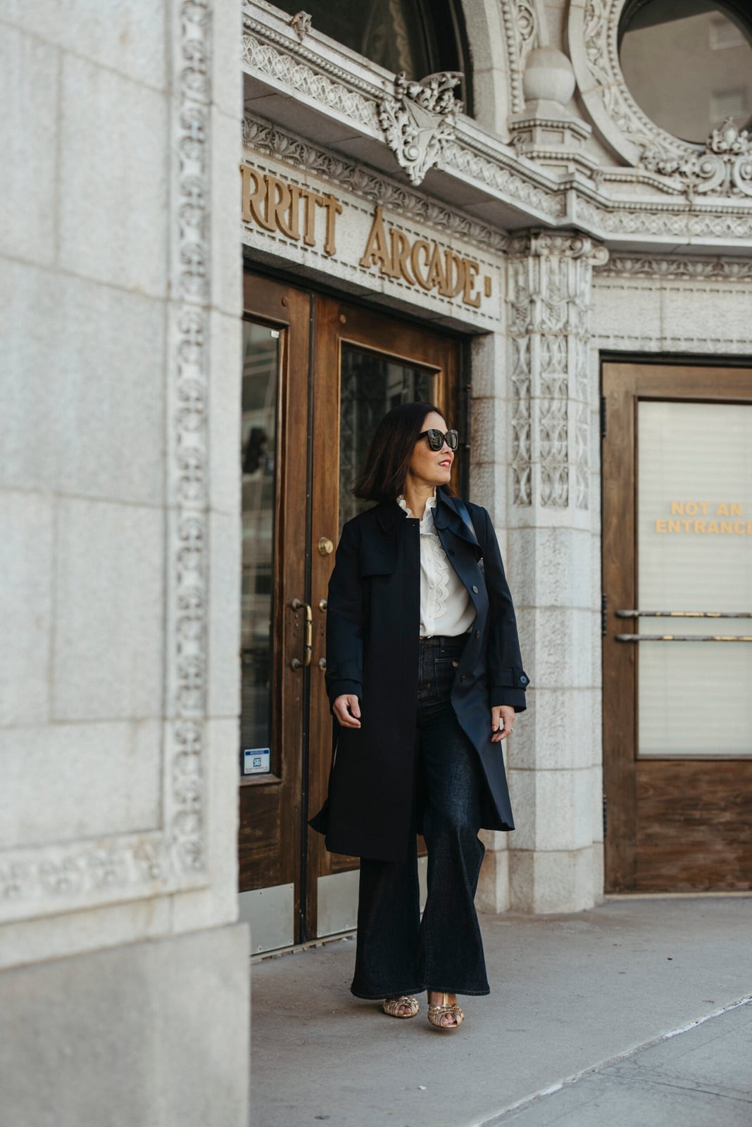 Black Trench Coat With Ruffled Blouse and Wide Leg Jeans Black Trench Coat With Ruffled Blouse and Wide Leg Jeans — Black Trench Coat Outfit Ideas