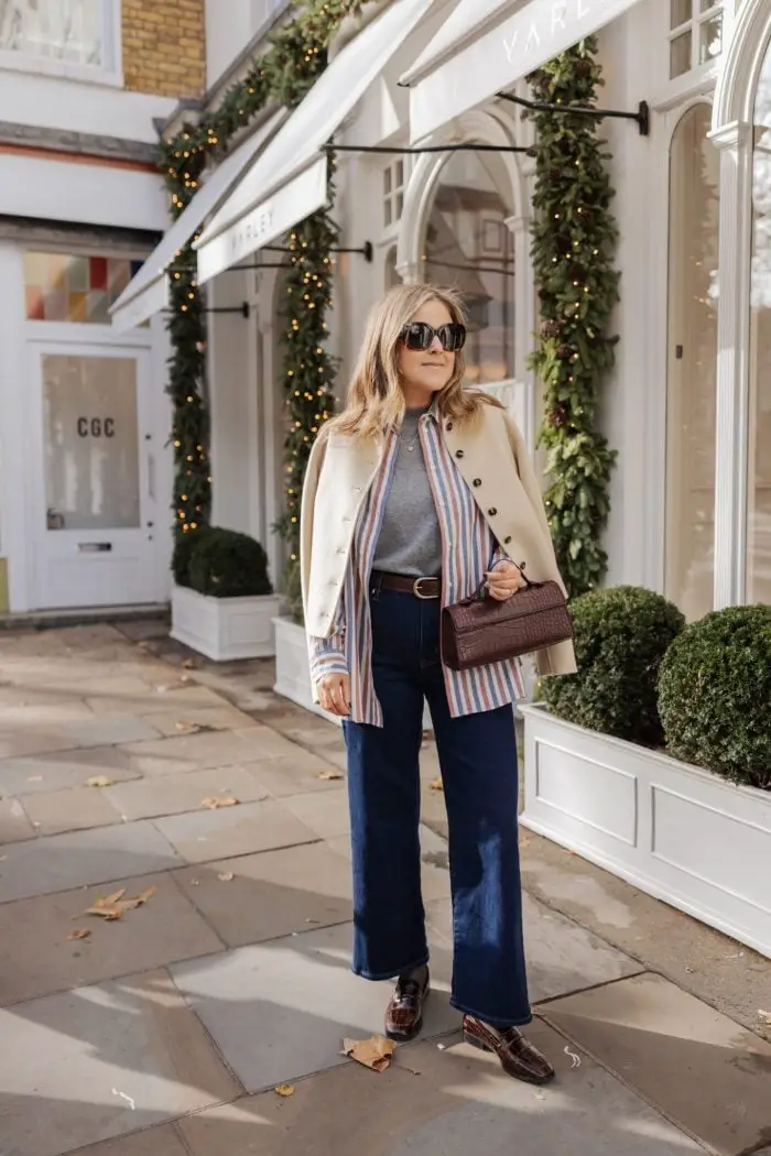Beige Jacket Draped Over Striped Shirt and Jeans Beige Jacket Draped Over Striped Shirt and Jeans — Classy London Outfits