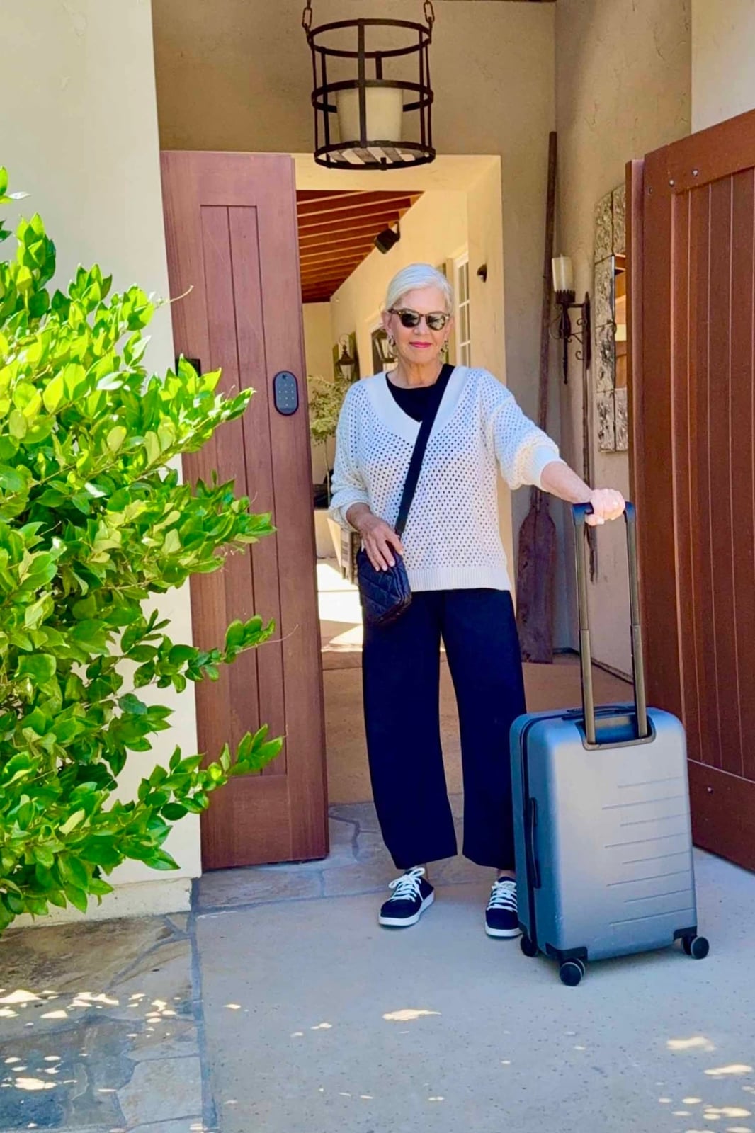 White Knit Cardigan Over Black T-Shirt and Navy Trousers — Classy Travel Outfits