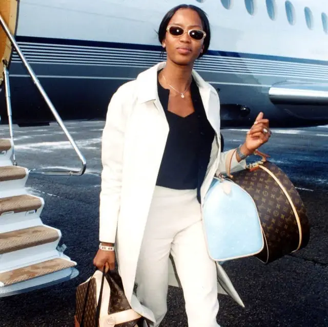 Cream Trench Coat Over Black Top and Tailored Trousers — Classy Travel Outfits