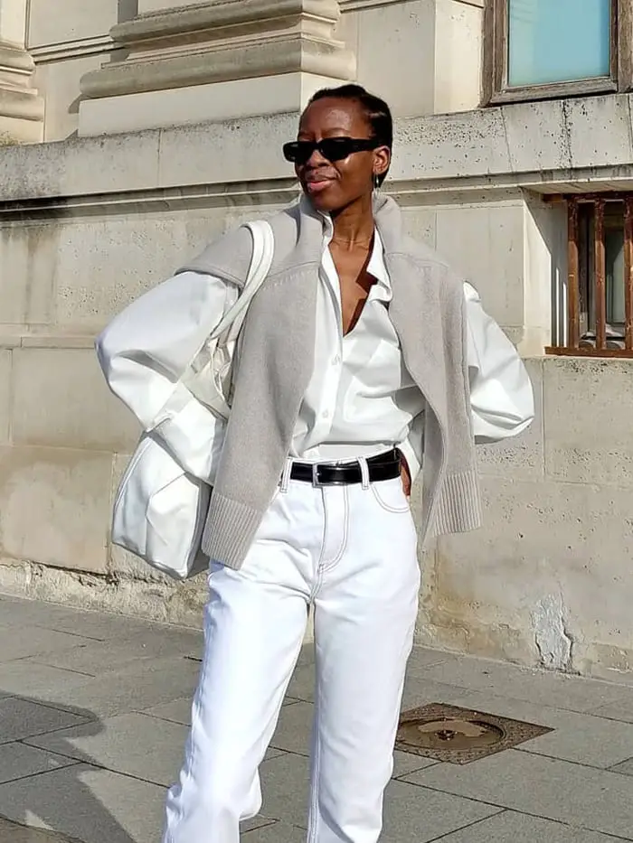 White Jeans With Gray Sweater Draped Over Shoulders — Classy White Jeans Outfits
