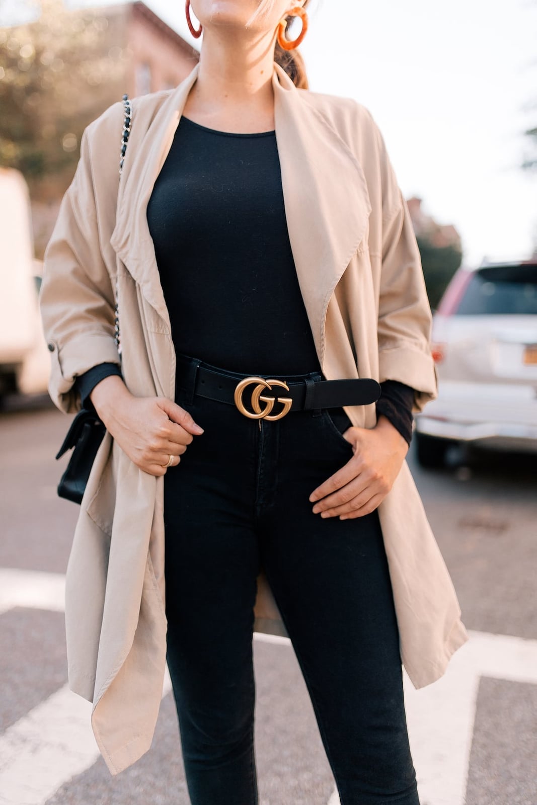 Beige Trench Coat Over Black Outfit With A Gold Logo Belt — Simple Photoshoot Outfits
