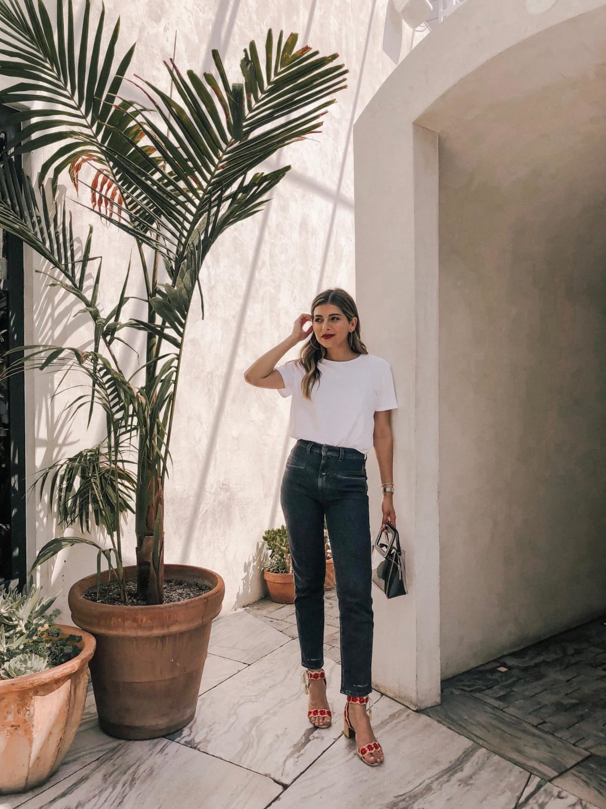 White T-Shirt With Dark Gray Jeans and Red Sandals With Embellishments White T-Shirt With Dark Gray Jeans and Red Sandals With Embellishments — Simple White Top Outfits