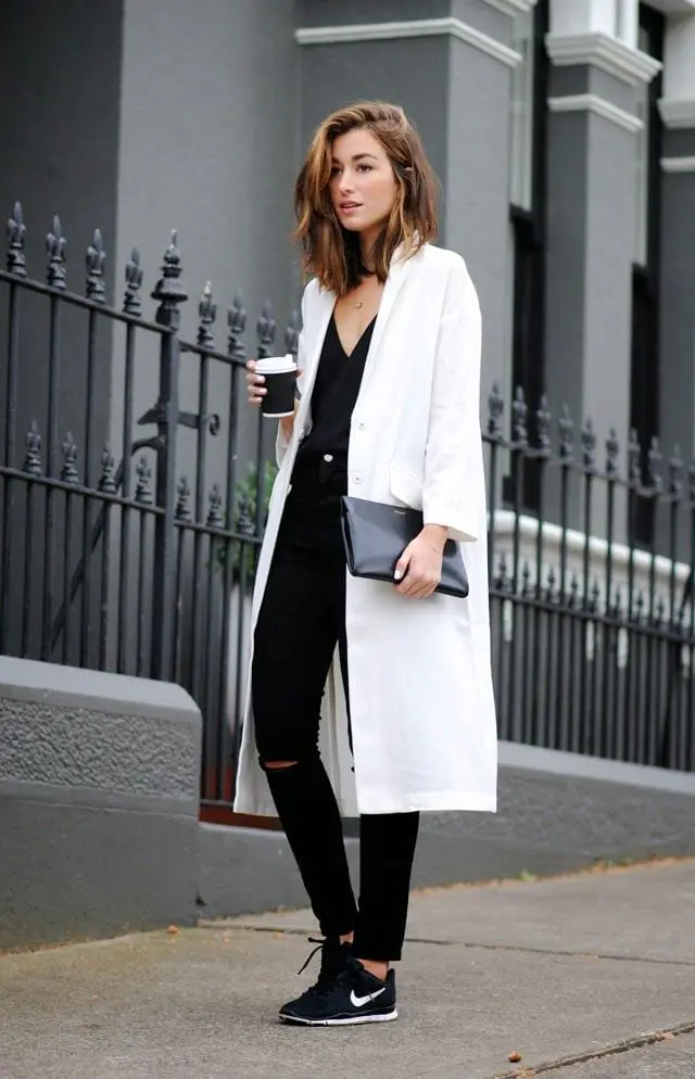 Long White Coat Over Ripped Black Jeans — Trendy Black and White Outfits