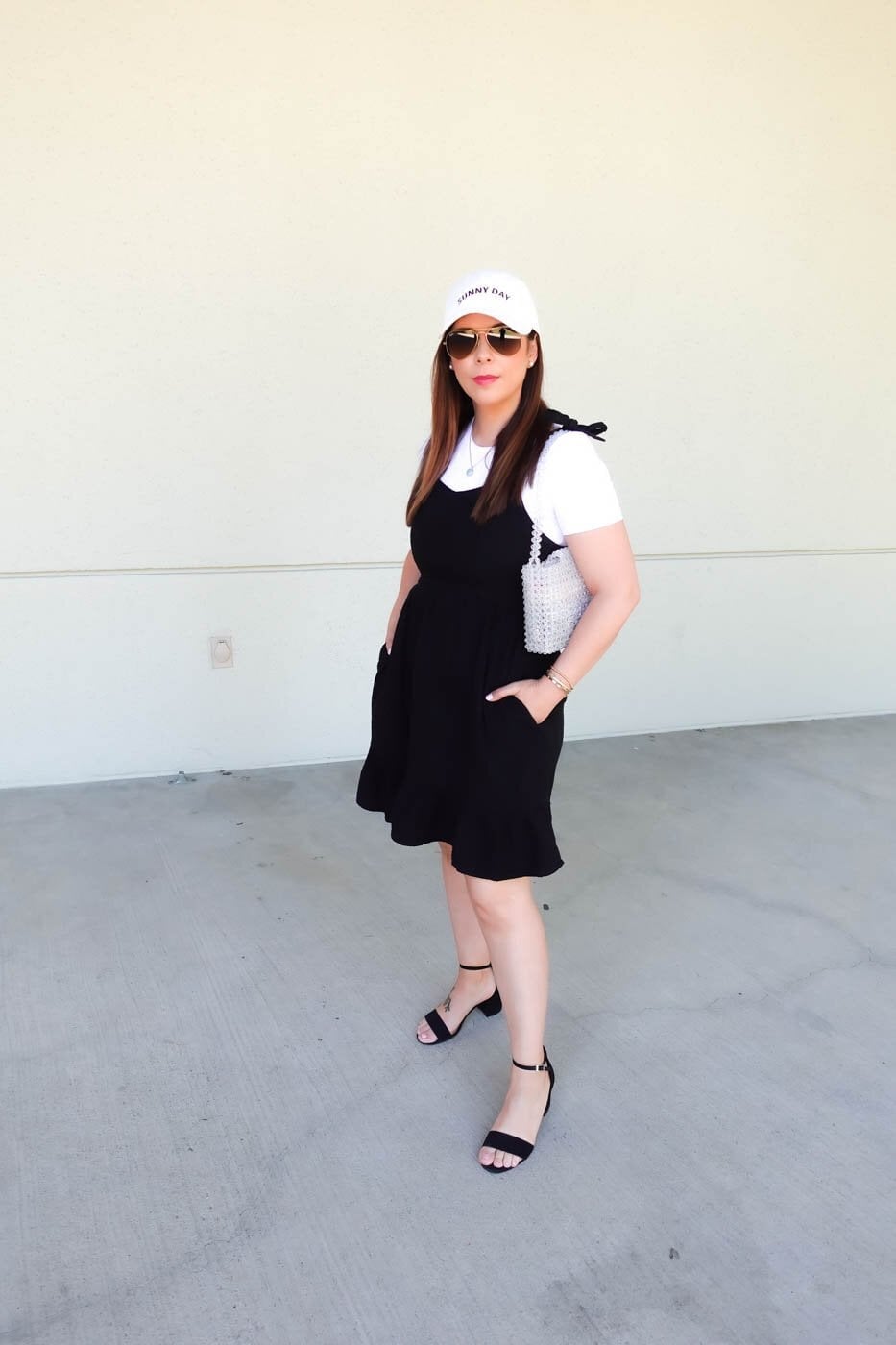 Black Pinafore Dress with Ruffled Hem and White T-Shirt — Trendy Black Dress Outfits