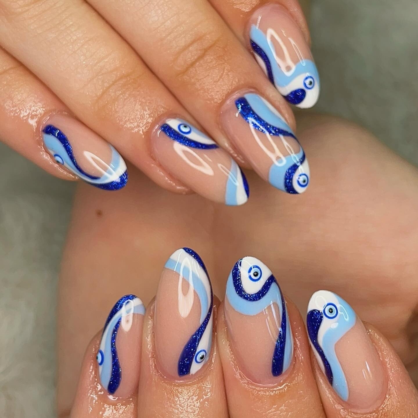 Short Almond Nude Base Blue White Swirls And Evil Eye, Close-Up Take — Trendy Evil Eye Nails