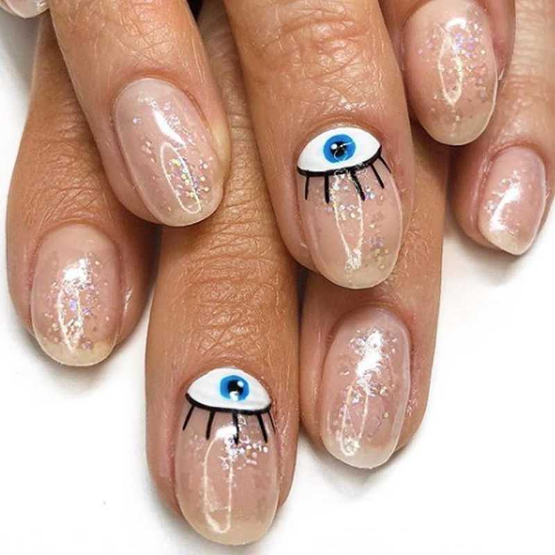 Short Oval Nude Base Glitter With Evil Eye Accents — Trendy Evil Eye Nails