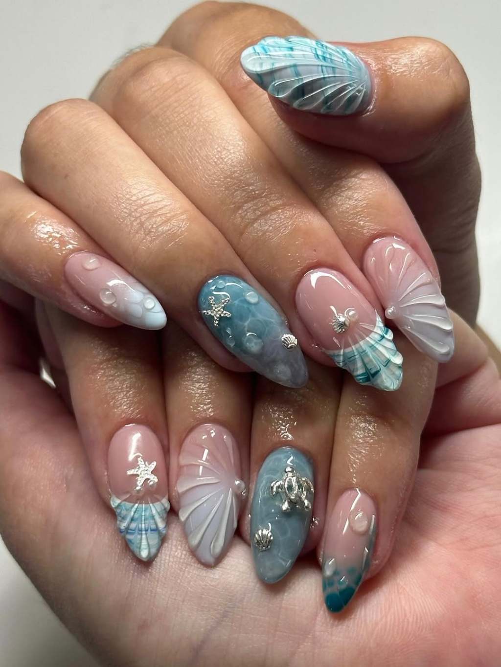 3D Seashells and Water Drops on Nude Almond Nails 3D Seashells and Water Drops on Nude Almond Nails — Trendy Ocean Nails