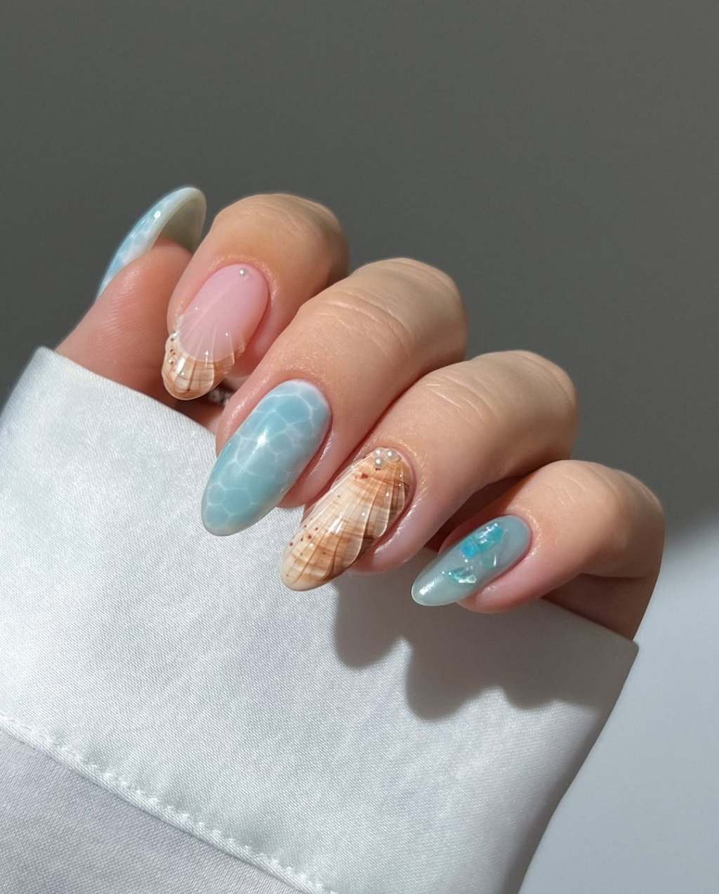 3D Seashells and Watery Patterns on Almond Nails 3D Seashells and Watery Patterns on Almond Nails — Trendy Ocean Nails