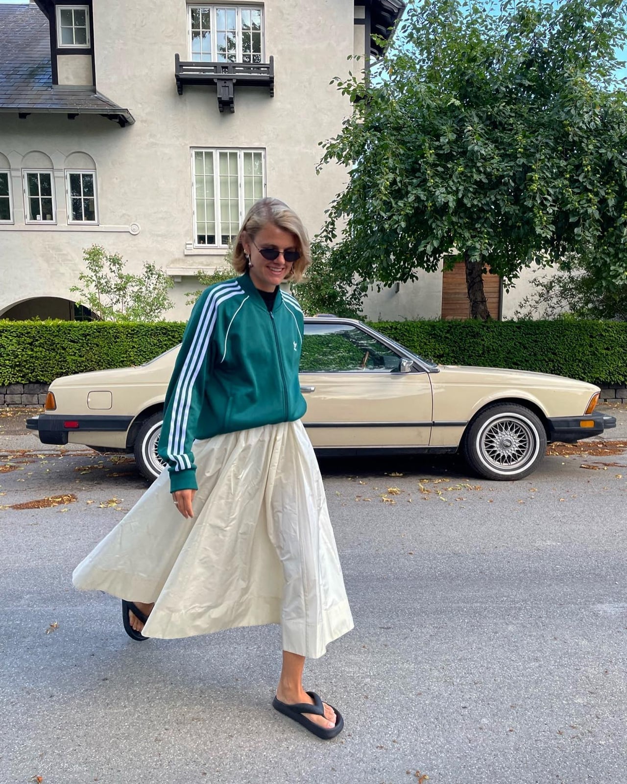 Green Track Jacket Over Black Top With Cream Skirt — Trendy Sporty Outfits